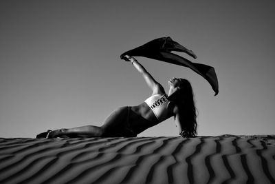 Woman with umbrella against clear sky