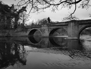 Arch bridge over river against sky