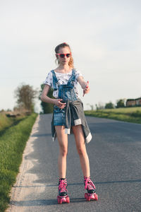 Full length of girl roller skating on road