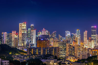 Illuminated buildings in city against sky at night