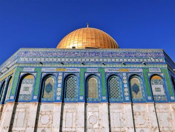 Low angle view of the dome of the rock against blue sky