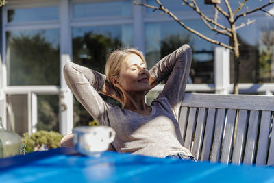 Woman relaxing on garden bench