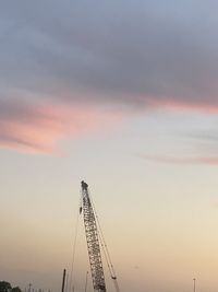 Low angle view of crane against sky during sunset