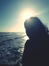 Man looking at sea against sky during sunset