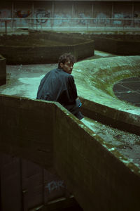 Side view of man standing by fountain