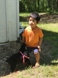 Boy with dog standing in grass