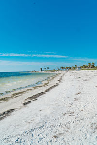 Scenic view of beach against clear blue sky