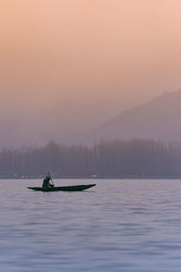 Boat in sea against sky during sunset