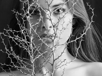 Close-up portrait of young woman with thorns