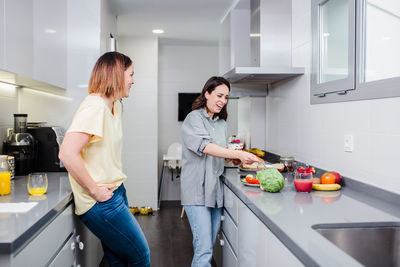 Friends having general talks in kitchen at home