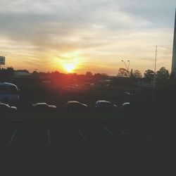 Cars moving on the road against cloudy sky