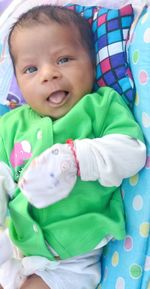 Portrait of cute baby girl lying on bed