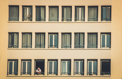Man looking through building window