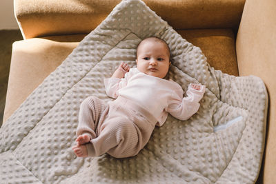 Portrait of a 1 month old baby. cute newborn baby lying on a developing rug.