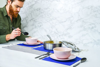 Bearded man having food in home