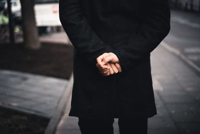 Rear view of man standing on footpath