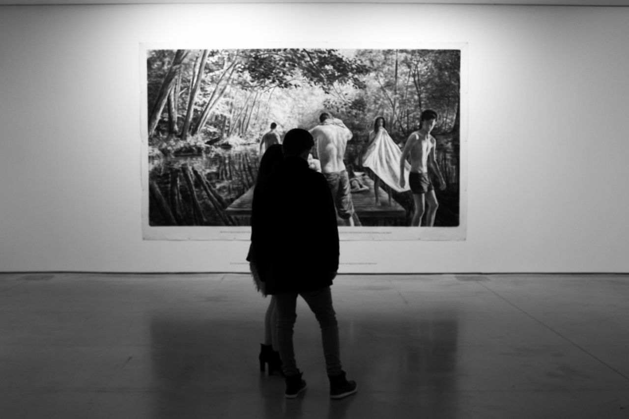 REAR VIEW OF WOMEN STANDING AT MUSEUM