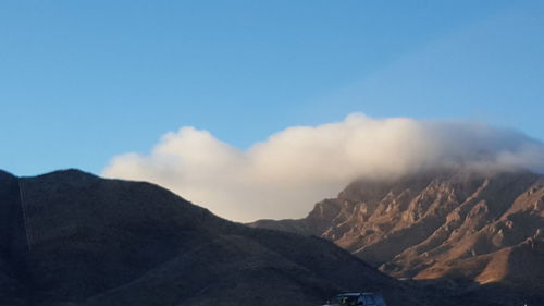 Scenic view of mountains against blue sky