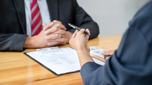 Midsection of business colleagues working on table