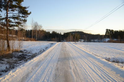 Snow covered landscape against clear sky