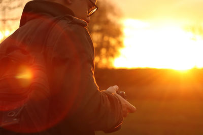 Man photographer hold camera on sunny nature background. copy space. banner