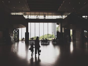 Silhouette people walking in corridor of building
