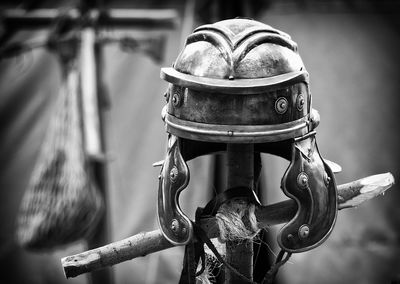 Close-up of rusty helmet on sticks