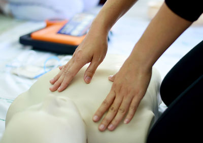 Cropped hands of woman performing cpr on dummy