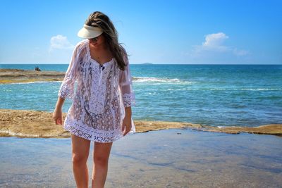 Woman standing on beach against sea