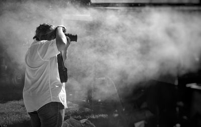 Side view of woman photographing outdoors