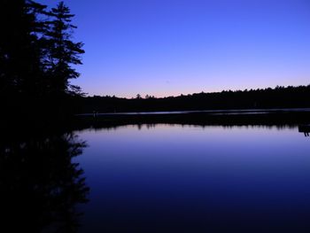 Scenic view of lake against clear sky at sunset