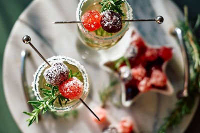 Christmas cocktail with sparkling wine, rosemary and cherry. winter holidays champagne drink.