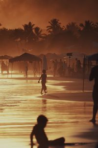 Silhouette people on beach during sunset