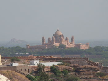 Umaid bhawan palace in city against sky during foggy weather