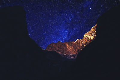 Low angle view of rock formation against sky at night