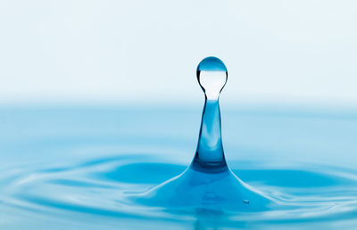 Close-up of blue water splashing in sea against sky