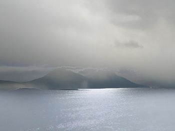 Scenic view of sea and mountains against sky