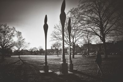 Statue of bare trees against sky