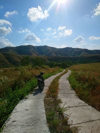 Road leading towards mountains against sky