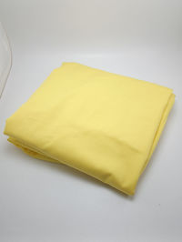 High angle view of yellow paper against white background