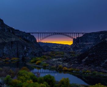 Bridge over river against sky during sunset