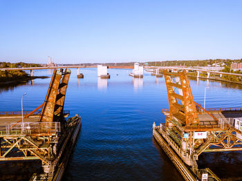 Bridge over sea against clear blue sky