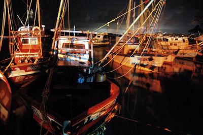 Close-up of boats moored in illuminated at night