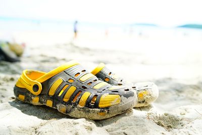 Close-up of yellow shoes on beach