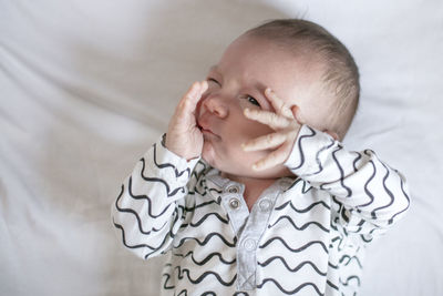 Close-up of baby boy lying on bed at home