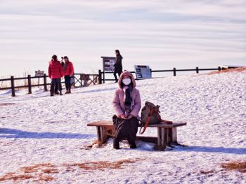 People sitting on bench in snow