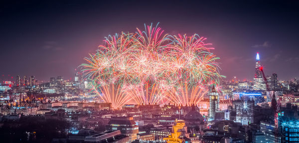 High angle view of firework display at night