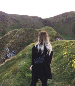 Rear view of woman standing on mountain