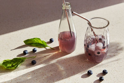 Summer natural organic drink with blueberries, basil extract, ice, shadows. refreshing soft drink