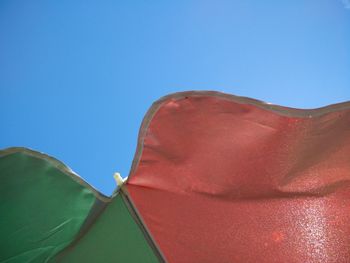 Low angle view of beach umbrella against clear blue sky